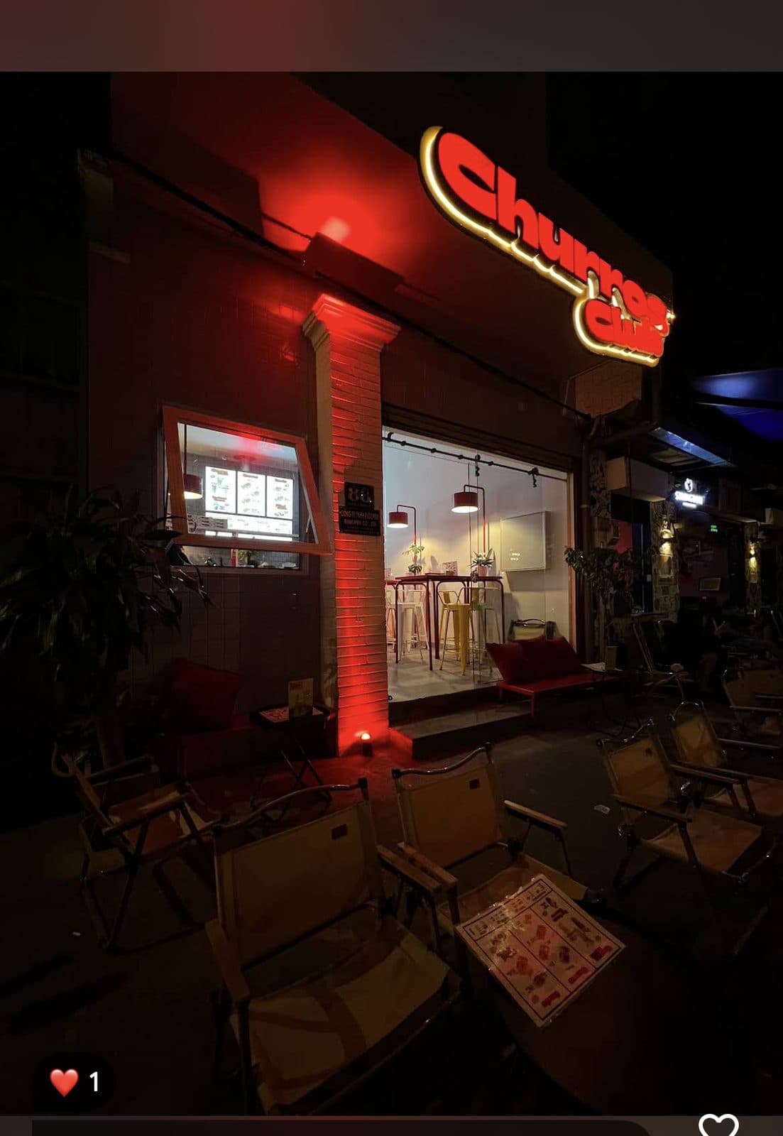 Churros Club storefront glowing at night