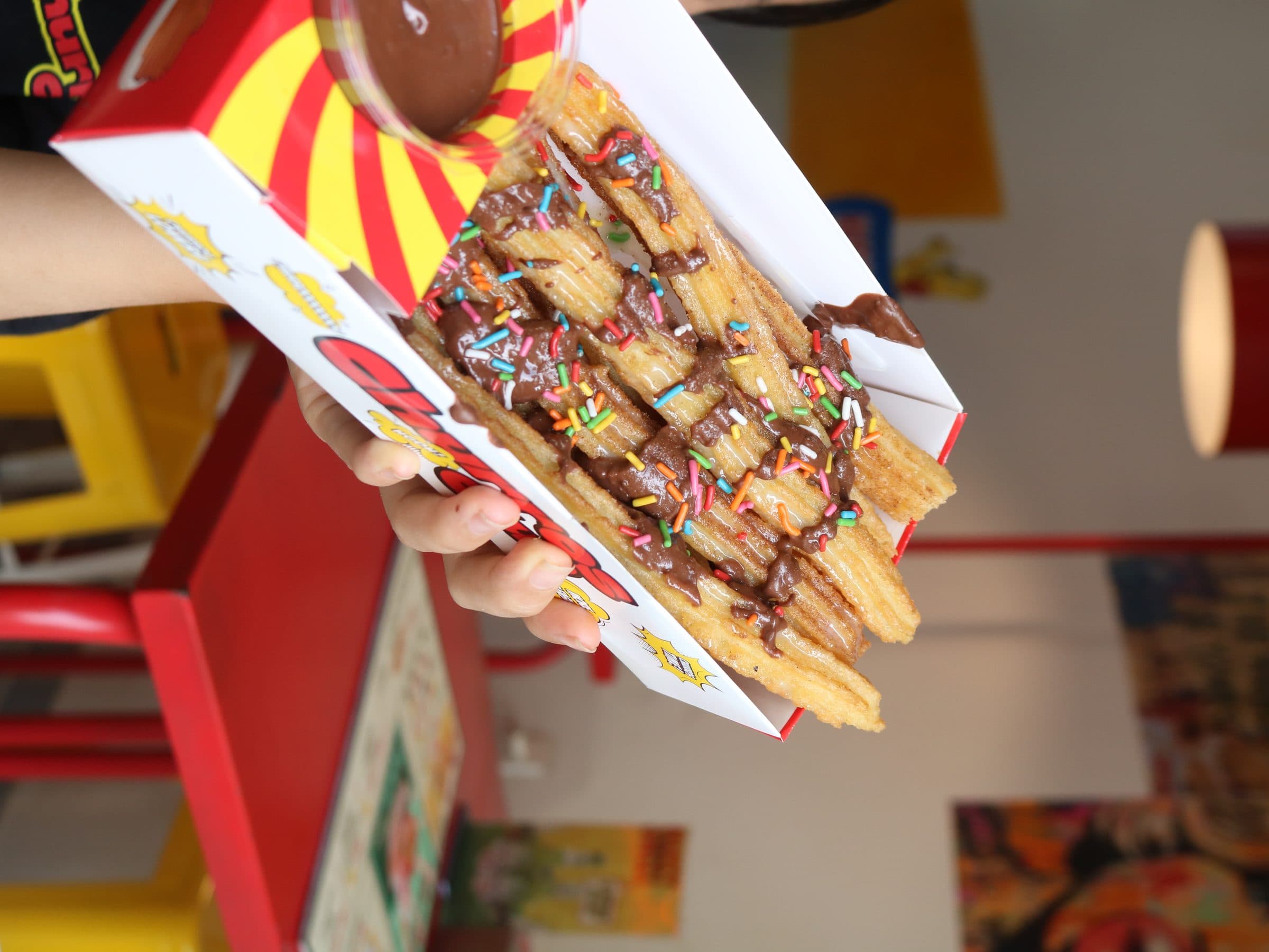 Close-up of churros loaded with chocolate and sprinkles