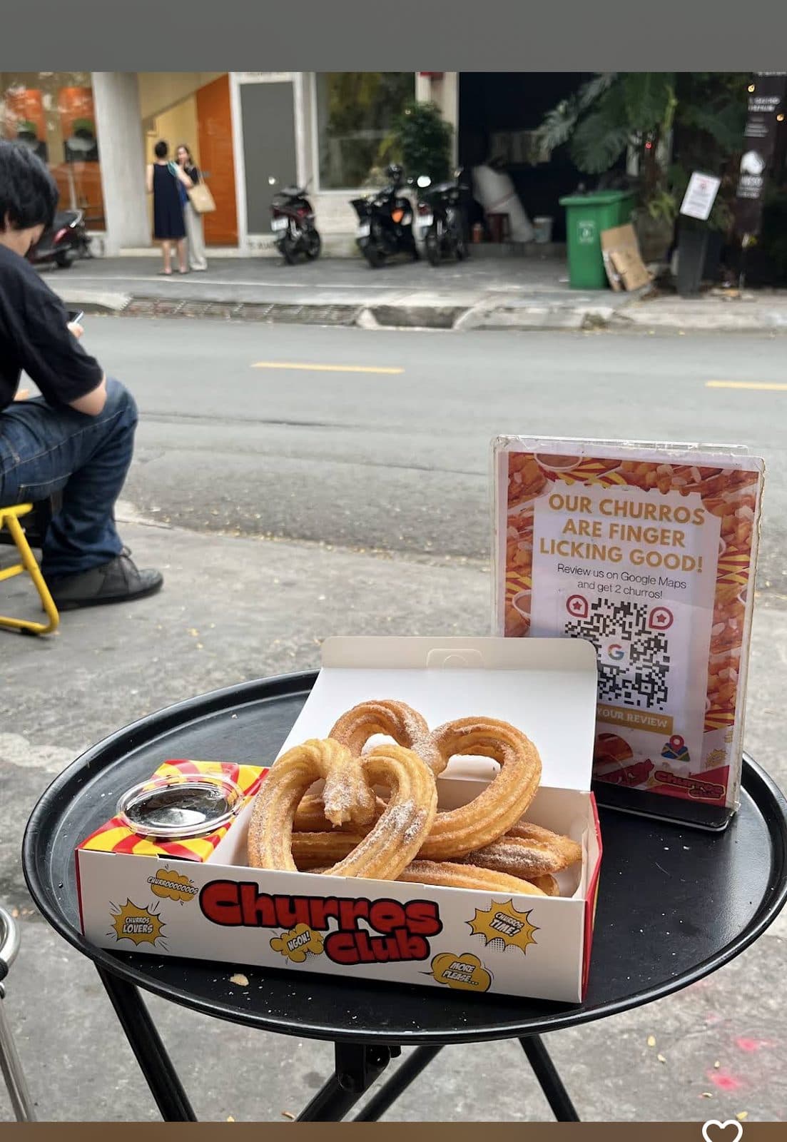 Box of churros on a streetside table outside the shop